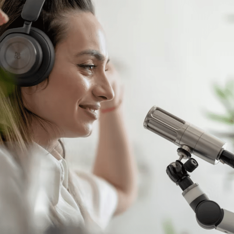 Woman wearing headphones speaking into a microphone